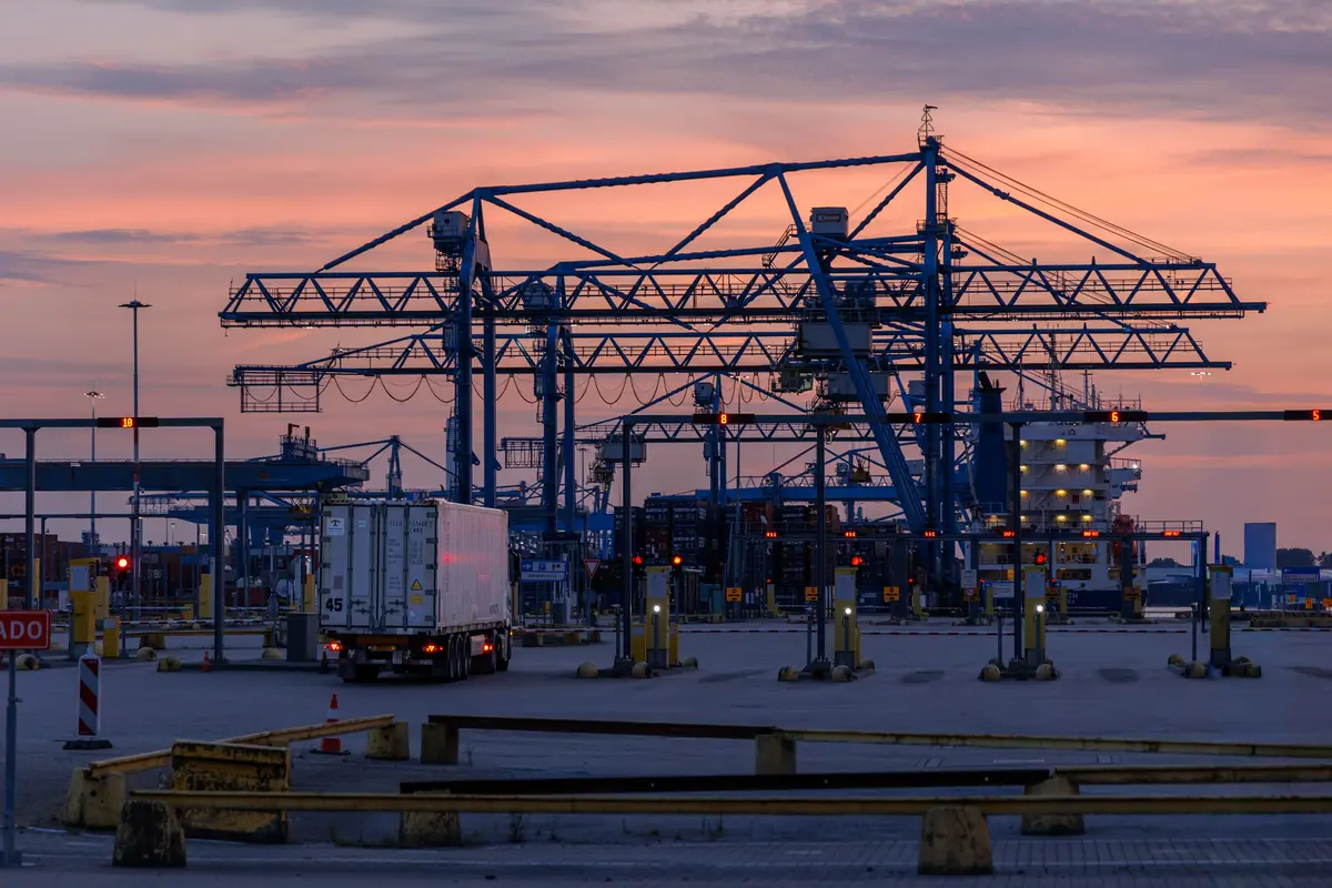 Terminal portuaire avec portiques, navire et camion de transport